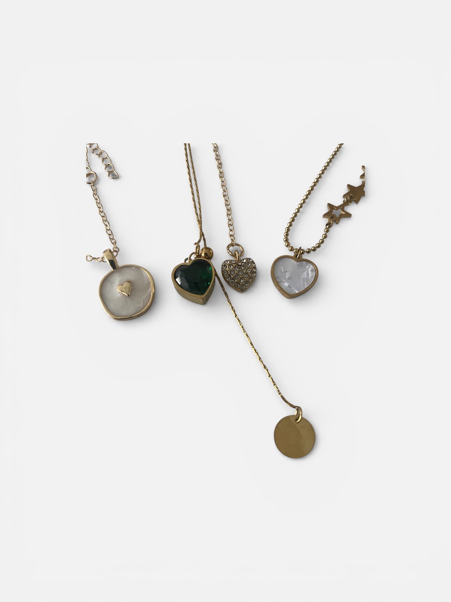 Four necklaces with various pendants on a white background