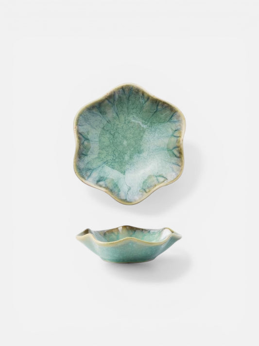 Two green ceramic bowls with gold edges on a white background