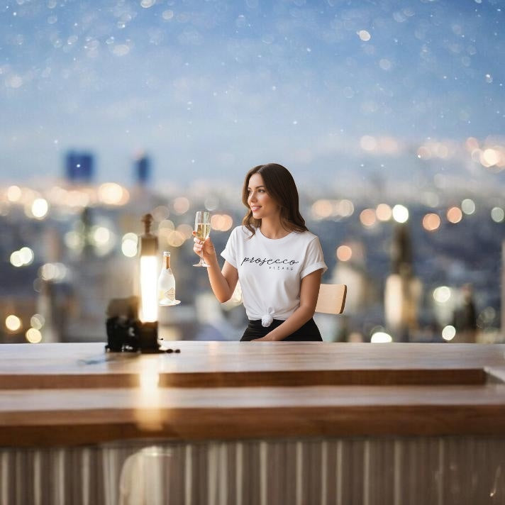 Woman holding a glass of champagne on a rooftop at night with city lights in the background