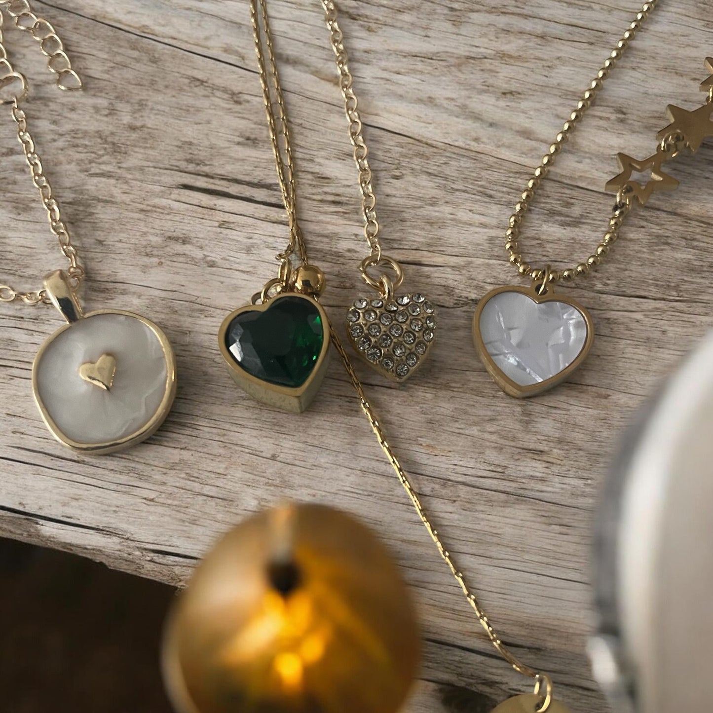 Gold necklaces with heart-shaped pendants on a wooden surface
