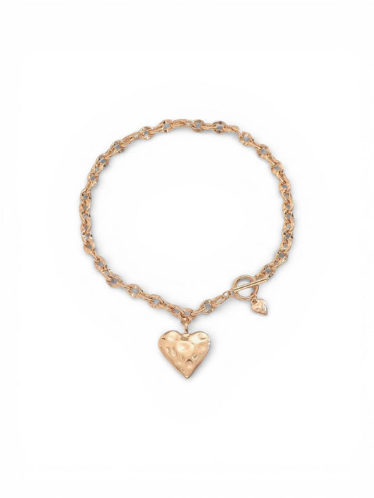Gold necklace with a heart-shaped charm on a white background