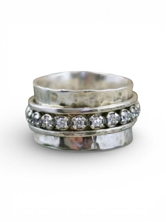 Stack of silver rings with diamond accents on a white background