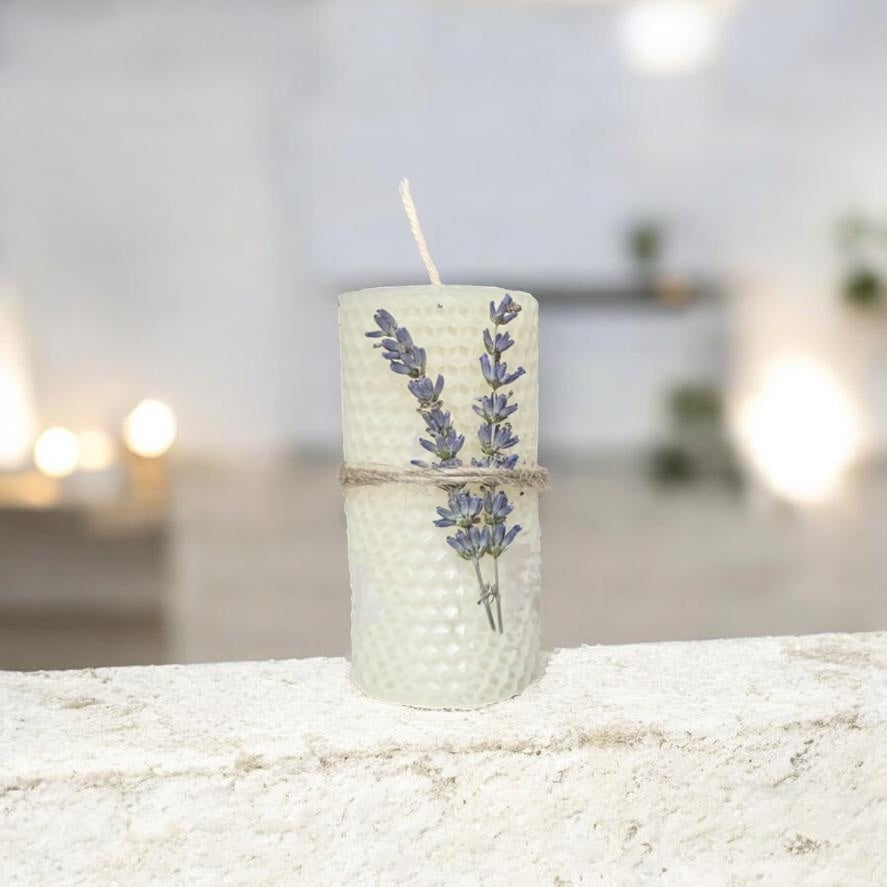 Decorative candle with lavender on a textured surface with a blurred background