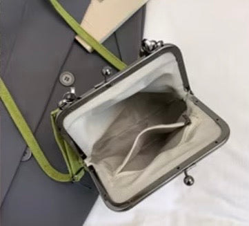 Small bag with a green strap on a white background