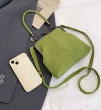 Green crossbody bag with a phone on a white background