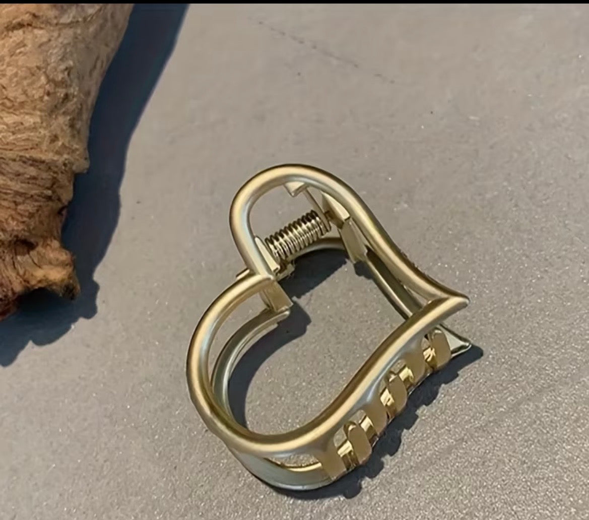 Gold metal clip on a sandy surface