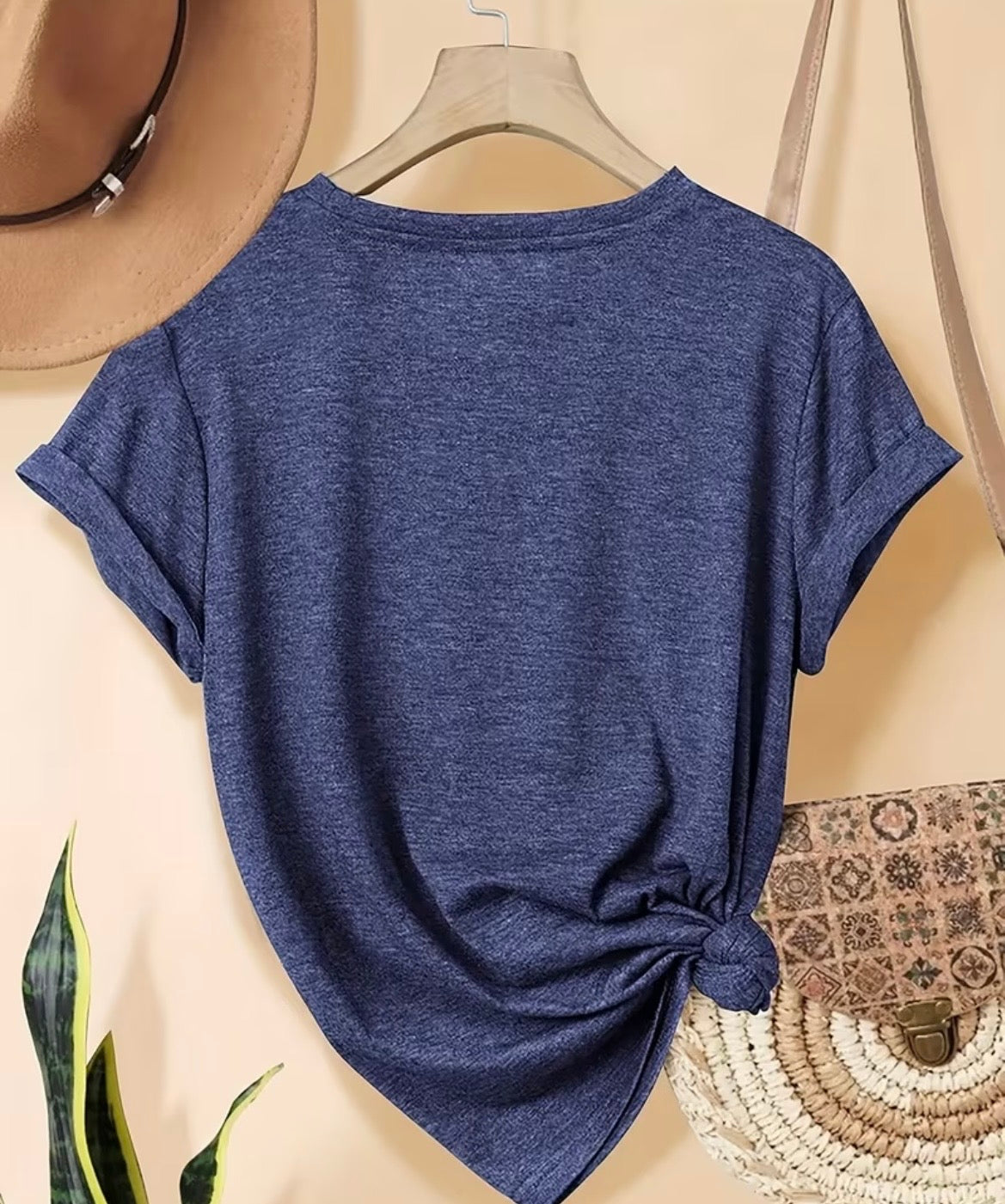 Blue t-shirt on a hanger with a beige background