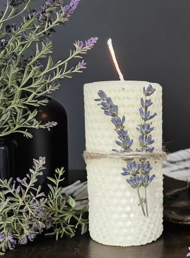 Decorative candle with lavender design on a dark background