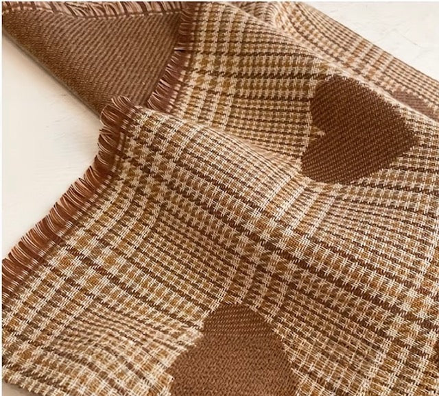 Brown and beige checkered fabric with heart shapes on a white background
