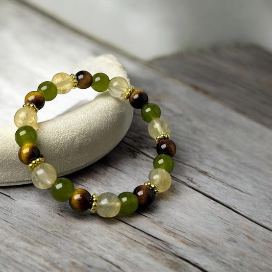 Beaded bracelet with green and brown stones on a wooden surface
