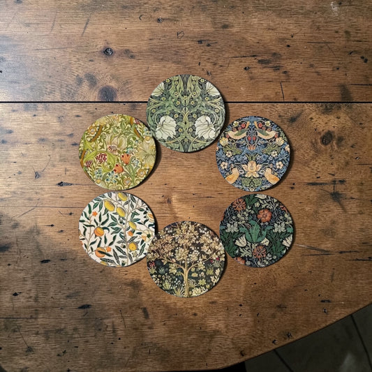 Set of six floral coasters on a wooden surface
