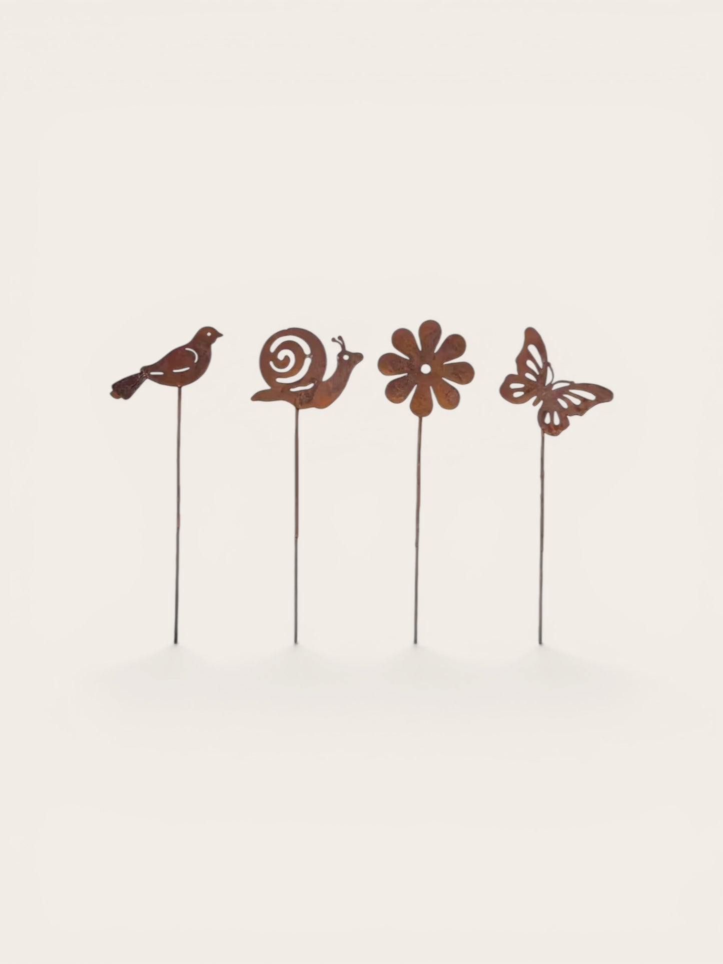Decorative garden stakes with bird, snail, flower, and butterfly designs on a beige background.