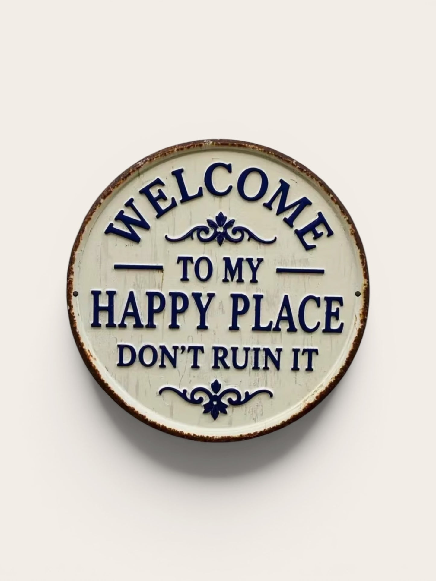 Decorative plate with text 'Welcome to my happy place don't ruin it' on a beige background