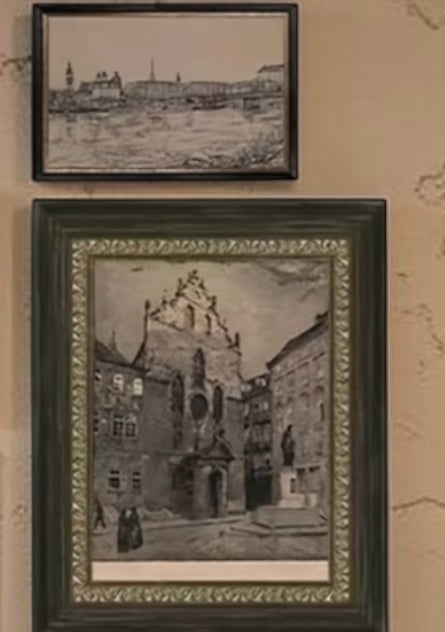 Two framed black and white artworks on a textured wall.